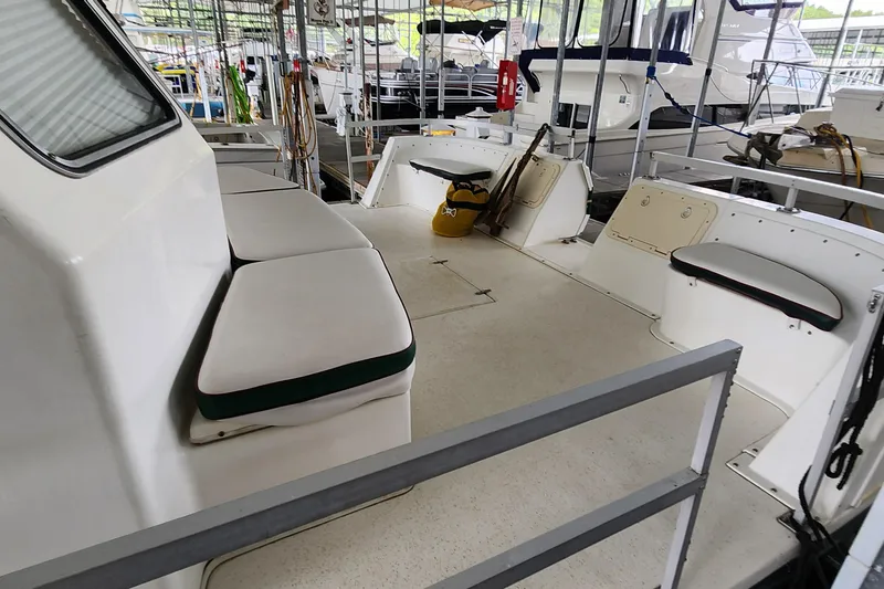 Slide: The Image of 1993 Gibson 50 Cabin Yacht interior with cushioned seating and spacious deck. - 32