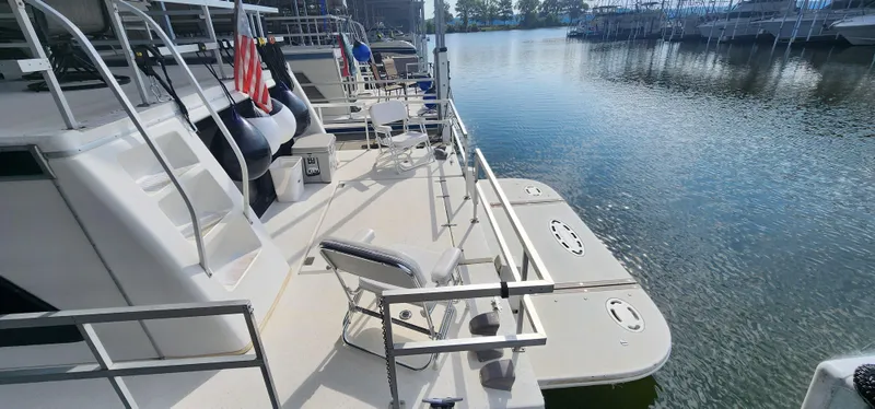 Slide: The Image of 1993 Gibson 50 Cabin Yacht docked at a marina, featuring spacious deck and seating. - 5