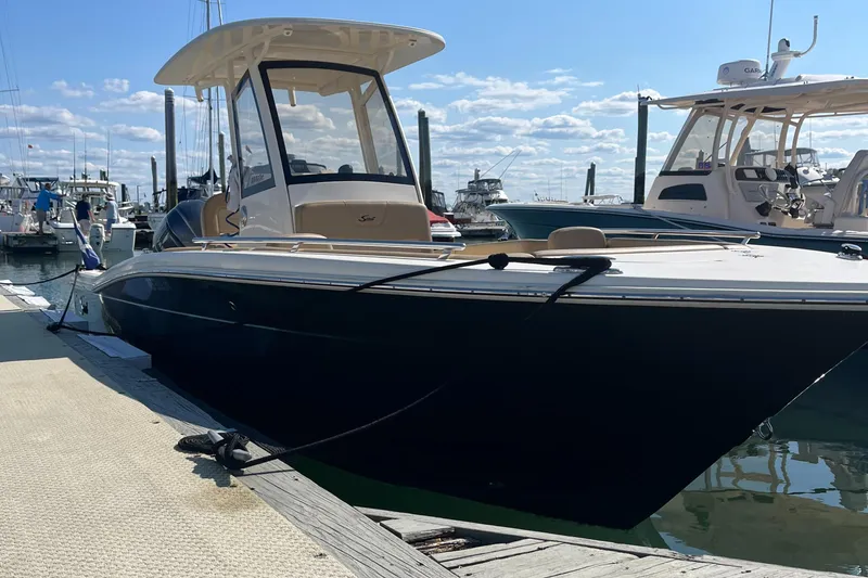 Slide: The Image of 2019 Scout 235 XSF boat docked at a marina on a sunny day. - 0