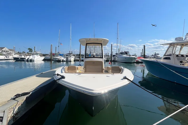 Slide: The Image of 2019 Scout 235 XSF boat docked at a marina on a sunny day. - 1