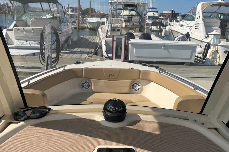 Slide: The Image of View from the helm of a 2019 Scout 235 XSF boat docked at a marina. - 13