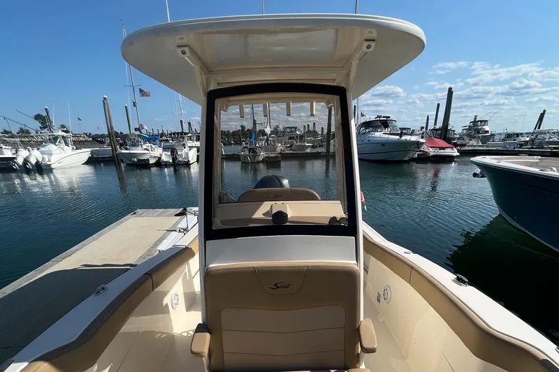 Slide: The Image of 2019 Scout 235 XSF boat docked at a marina with other boats. - 14