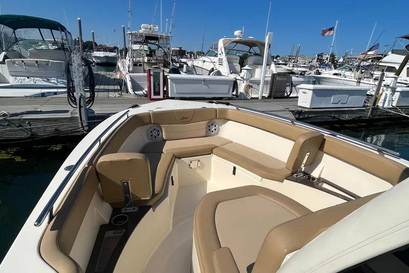Slide: The Image of 2019 Scout 235 XSF boat docked at a marina with other boats. - 16