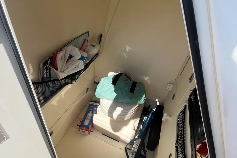 Slide: The Image of Storage compartment of a 2019 Scout 235 XSF boat with various items. - 17