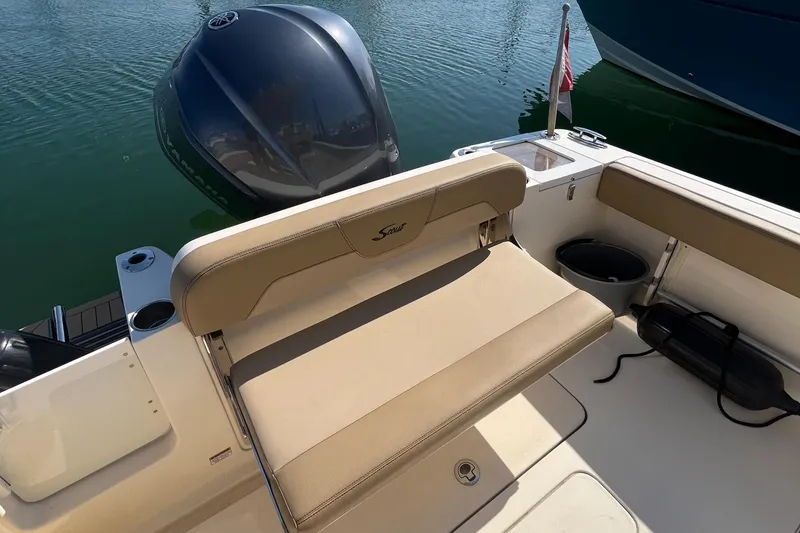 Slide: The Image of 2019 Scout 235 XSF boat interior with beige seating and outboard motor. - 22