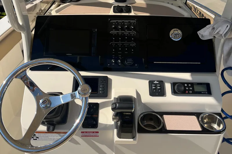 Slide: The Image of 2019 Scout 235 XSF boat dashboard with steering wheel, controls, and navigation equipment. - 4
