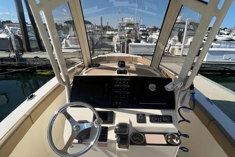 Slide: The Image of 2019 Scout 235 XSF boat dashboard and steering wheel at marina. - 5