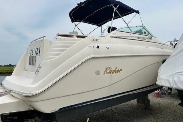The Image of 2001 Rinker 270 Fiesta Vee boat with canopy, docked on land. - 1