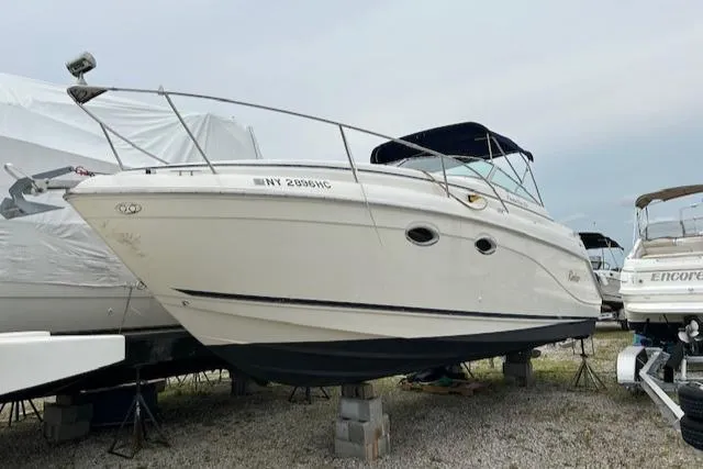 Slide: The Image of 2001 Rinker 270 Fiesta Vee boat on stands, white hull, outdoor storage. - 3