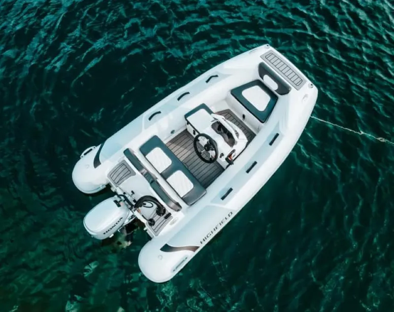 Slide: The Image of 2024 Highfield Sport 300 inflatable boat on clear blue water. - 4