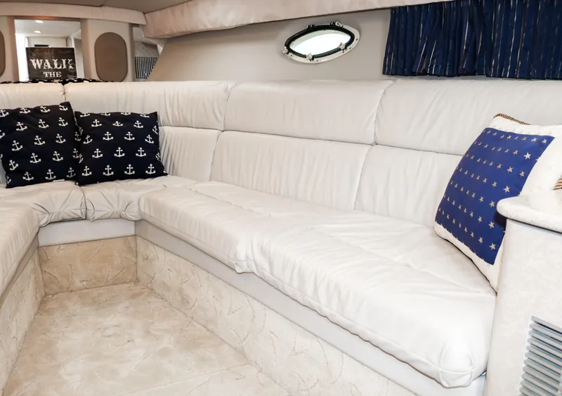 Slide: The Image of Interior of 2003 Formula 370 Super Sport with white leather seating and nautical-themed pillows. - 17