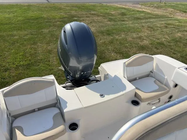 Slide: The Image of 2019 Robalo R180 boat with outboard motor and seating, on grassy area. - 7