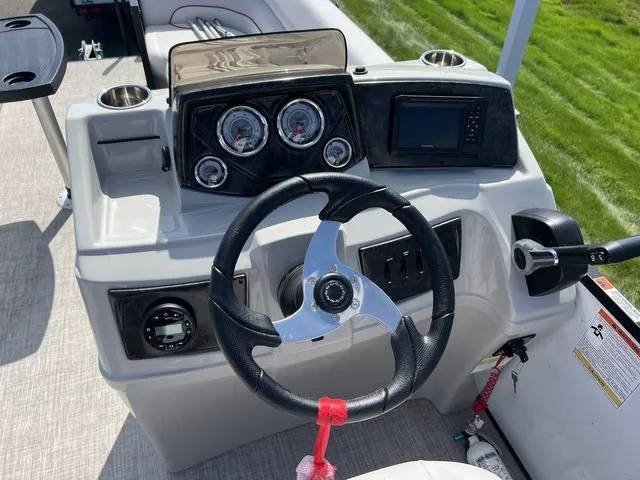 Slide: The Image of 2024 SunCatcher Select 22SS boat dashboard with steering wheel and gauges. - 11