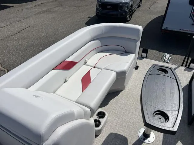 Slide: The Image of 2024 SunCatcher Select 22SS boat interior with white and red seating, black table, and cup holders. - 12
