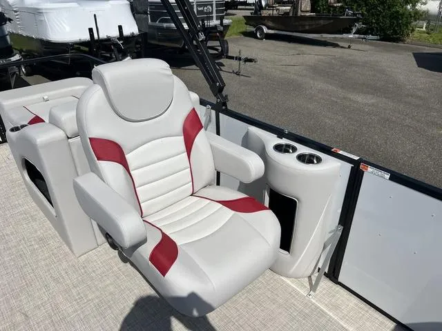 Slide: The Image of 2024 SunCatcher Select 22SS boat seat with red accents and cup holders. - 13