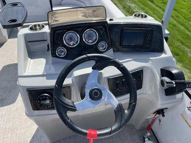 Slide: The Image of 2024 SunCatcher Select 22SS boat dashboard with steering wheel and control panel. - 16