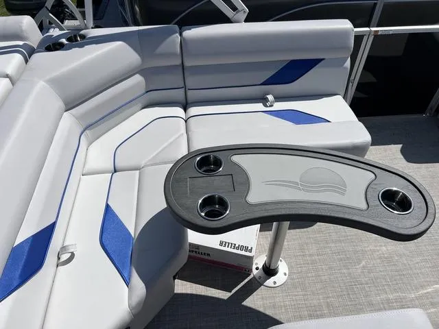 Slide: The Image of 2024 SunCatcher Select 18C boat interior with gray and blue seating, table with cup holders. - 11