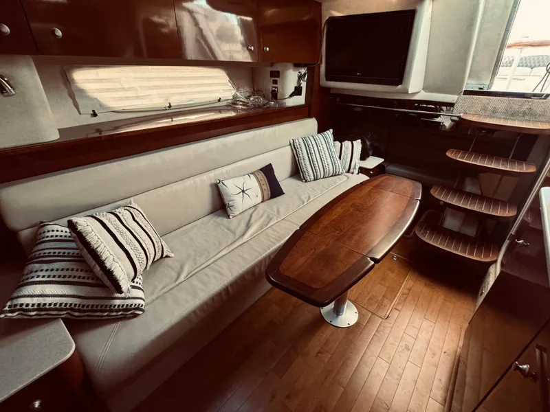 Slide: The Image of Interior of 2008 Sea Ray 350 Sundancer with sofa, wooden table, and TV. - 20