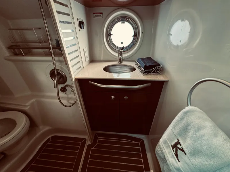 Slide: The Image of 2008 Sea Ray 350 Sundancer bathroom with sink, porthole, and towel rack. - 25