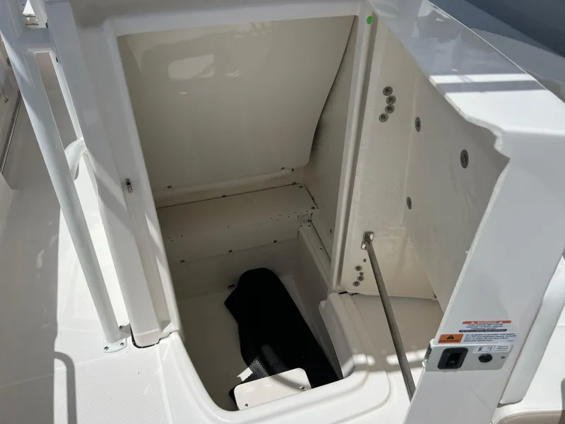 Slide: The Image of 2025 Robalo R200 Center Console storage compartment with open hatch. - 14