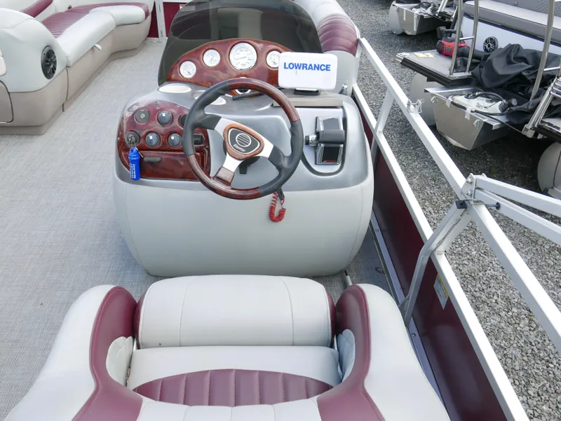 Slide: The Image of 2004 Tracker PB22OB boat dashboard with steering wheel and Lowrance fishfinder. - 9