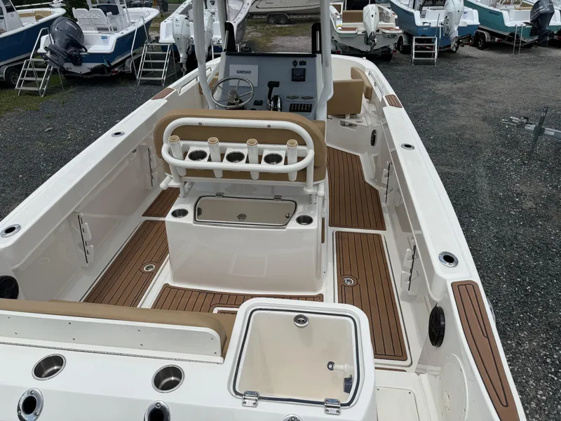 Slide: The Image of 2024 Bayliner Trophy T24CC boat interior with wood accents and fishing rod holders. - 25