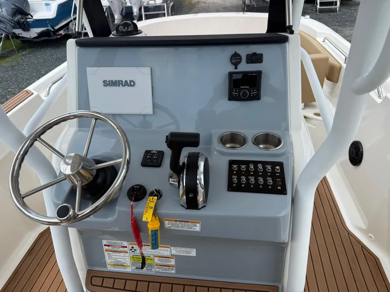 Slide: The Image of 2024 Bayliner Trophy T24CC helm with steering wheel, controls, and Simrad display. - 33
