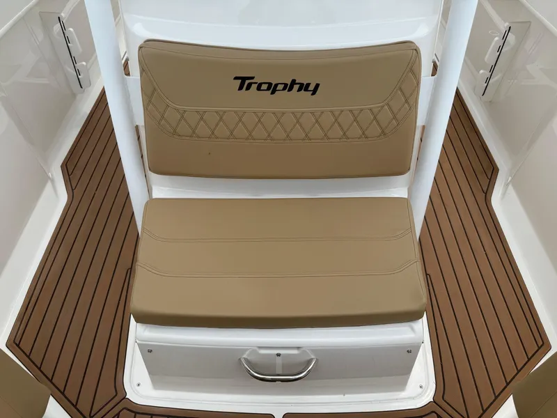 Slide: The Image of 2024 Bayliner Trophy T24CC boat seat with tan cushions and wood-patterned flooring. - 34