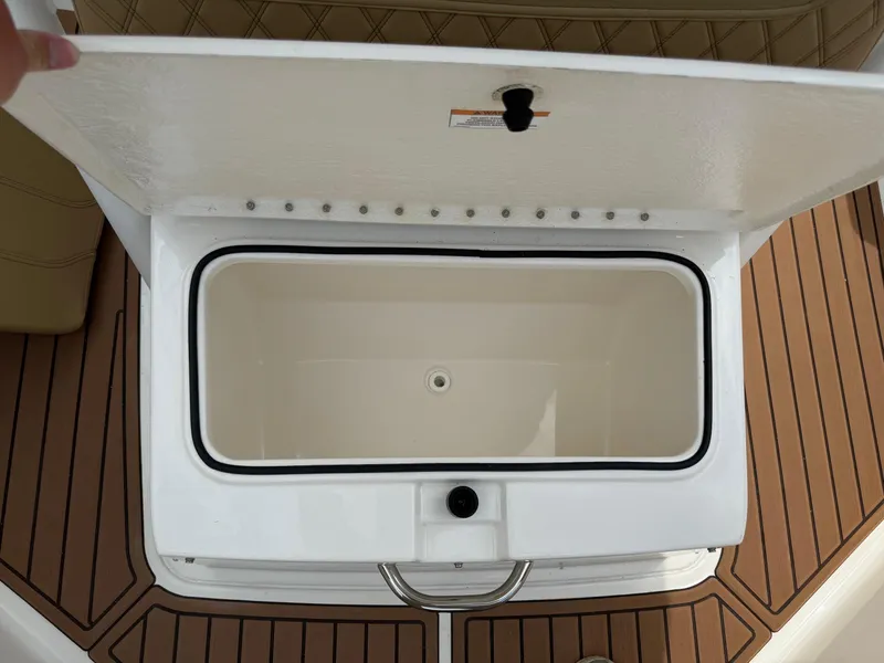 Slide: The Image of Open storage compartment on 2024 Bayliner Trophy T24CC boat, featuring teak-style flooring. - 36