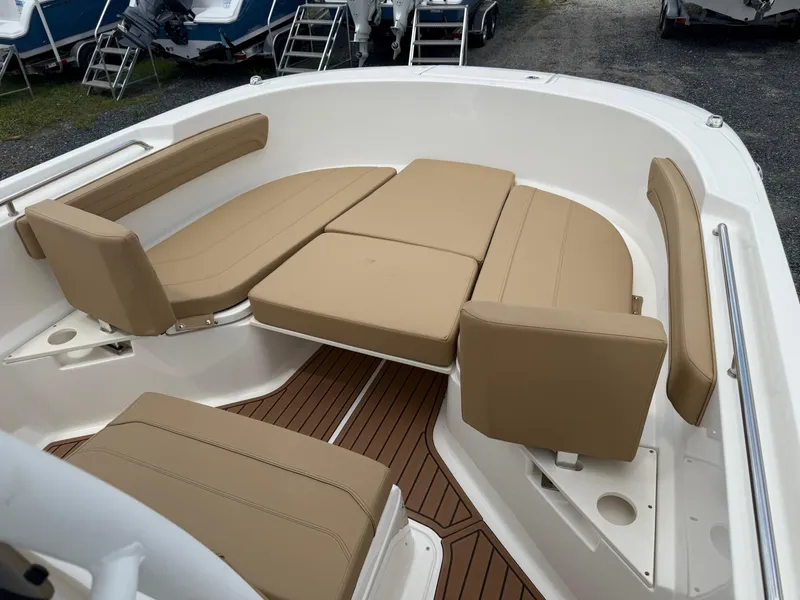 Slide: The Image of 2024 Bayliner Trophy T24CC boat interior with tan cushioned seating and wood-style flooring. - 37