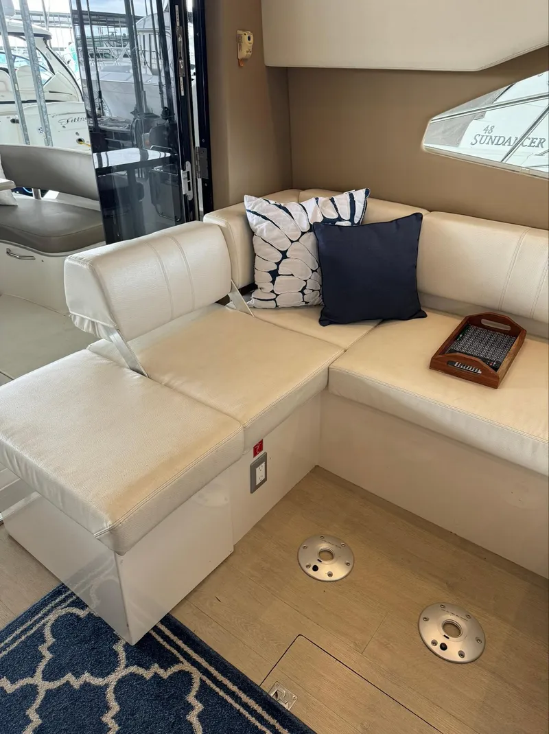 Slide: The Image of Interior seating area of a 2015 Carver C37 Coupe yacht with cushions and a tray. - 20
