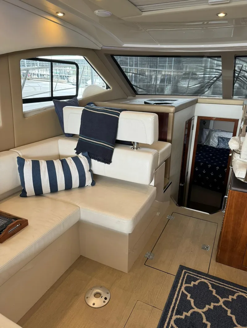 Slide: The Image of Interior of a 2015 Carver C37 Coupe yacht with beige seating and nautical decor. - 21