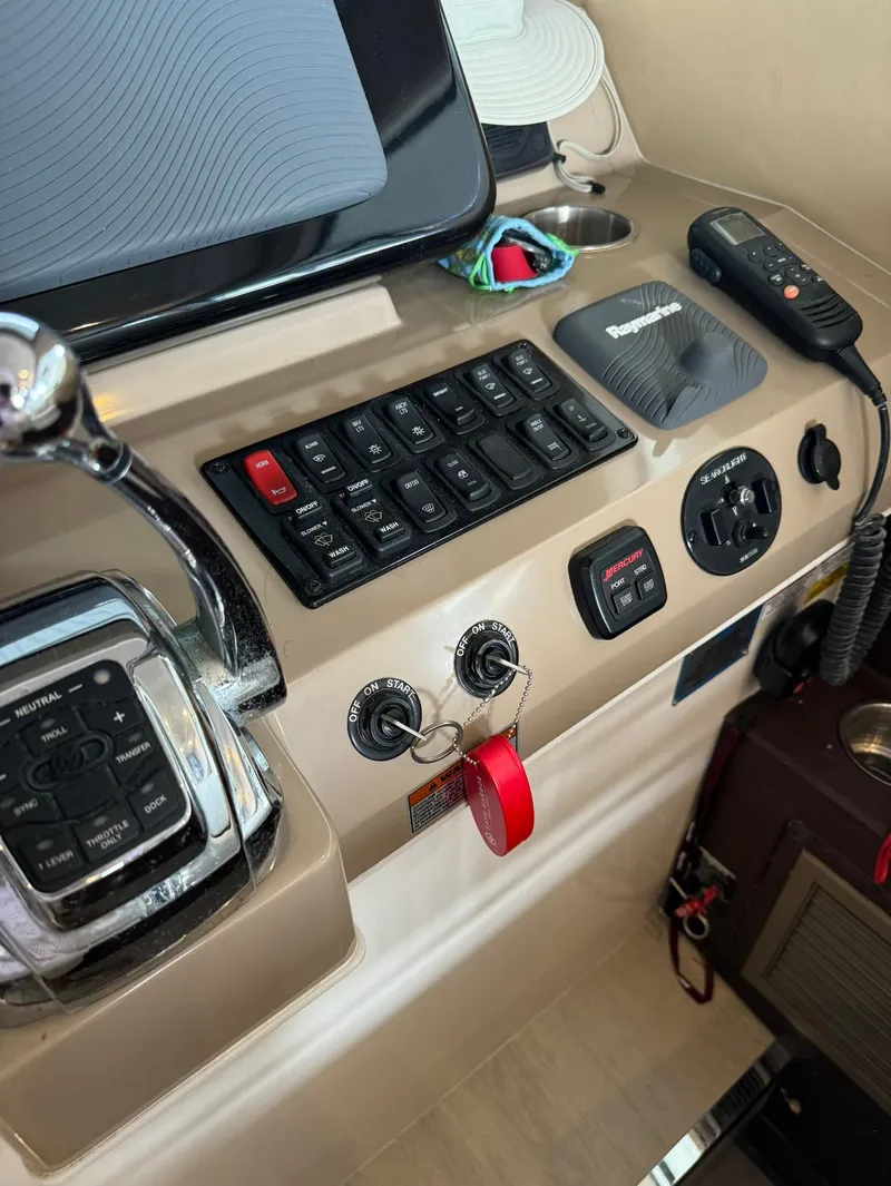 Slide: The Image of Control panel of a 2015 Carver C37 Coupe boat with various switches and keys. - 26