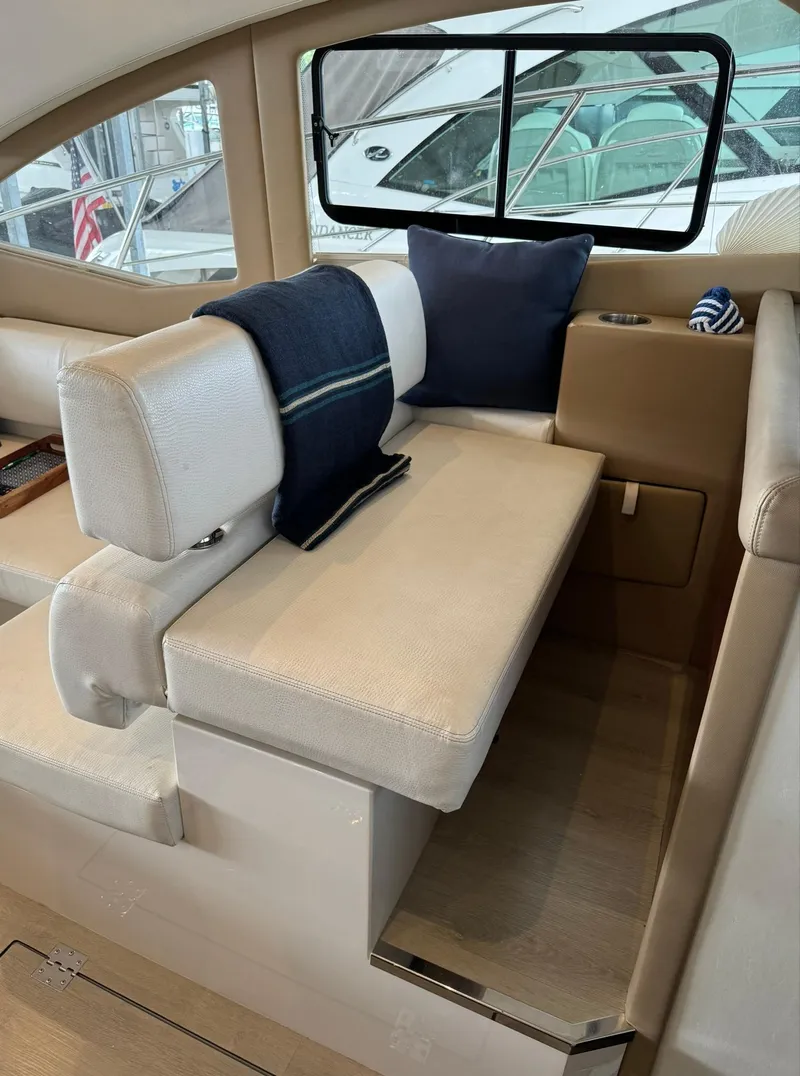 Slide: The Image of Interior seating area of a 2015 Carver C37 Coupe yacht with cushions and a blanket. - 29