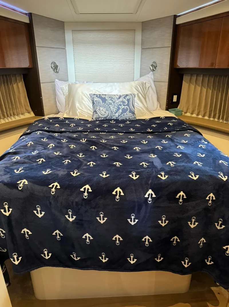 Slide: The Image of Luxurious bedroom in a 2015 Carver C37 Coupe yacht with anchor-themed bedding. - 32