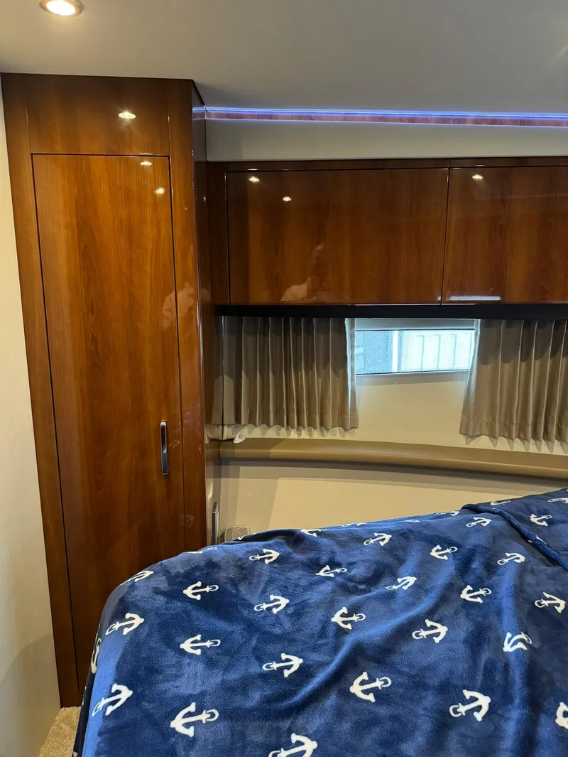 Slide: The Image of Interior cabin of 2015 Carver C37 Coupe with wooden cabinets and anchor-themed bedding. - 33