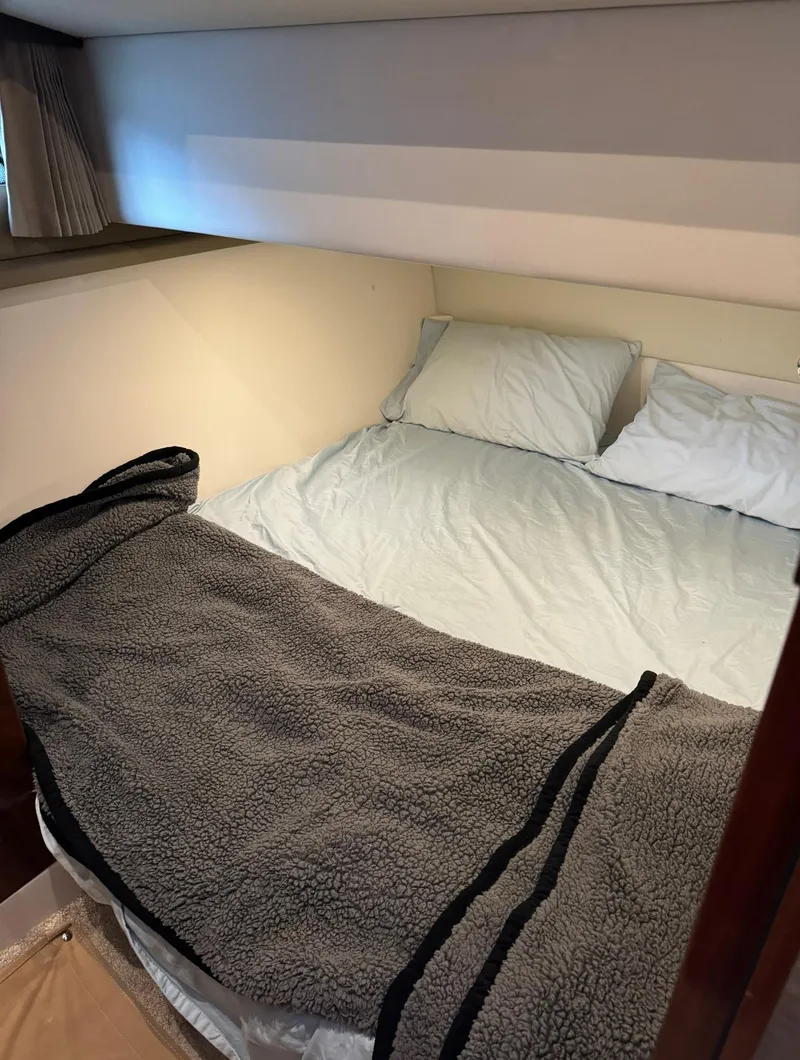Slide: The Image of Cozy bedroom in a 2015 Carver C37 Coupe yacht with a neatly made bed. - 35