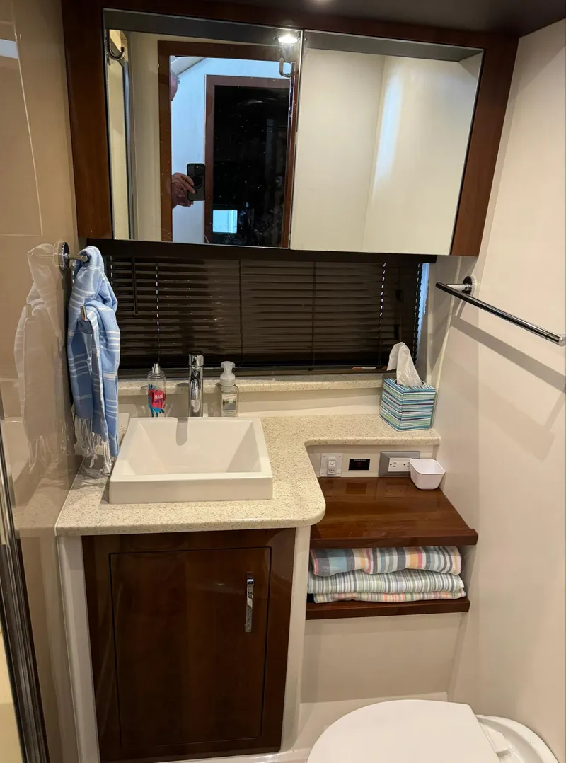 Slide: The Image of 2015 Carver C37 Coupe bathroom with sink, mirror, and storage shelves. - 39