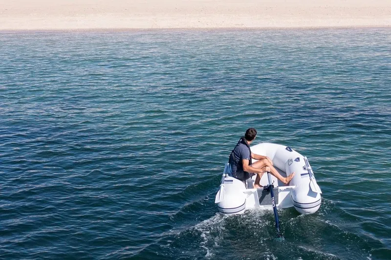 Slide: The Image of Person rowing Highfield Roll-Up 250 KAL boat, 2025 model, on open water. - 9