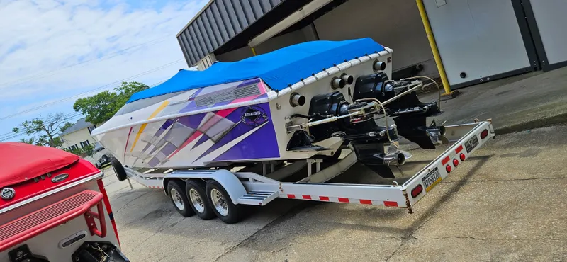 Slide: The Image of 1997 Outerlimits 37 Stiletto powerboat on a trailer with a blue cover. - 3