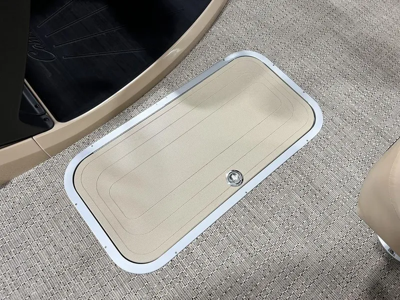 Slide: The Image of Barletta Cabrio C24UC 2025 boat floor storage compartment with beige carpet. - 15