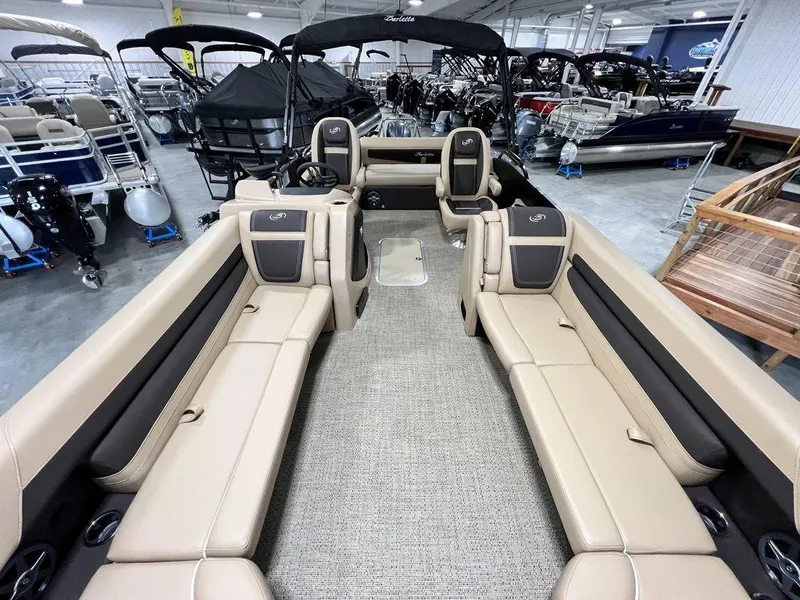 Slide: The Image of 2025 Barletta Cabrio C24UC pontoon boat interior with beige seating in showroom. - 21