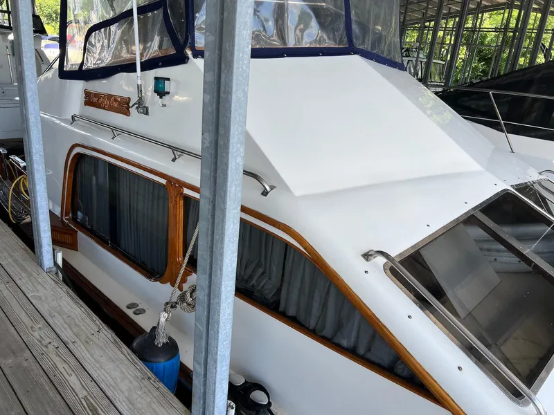 Slide: The Image of 1986 Midnight Lace 44 Flybridge Express Cruiser docked in a covered marina. - 14