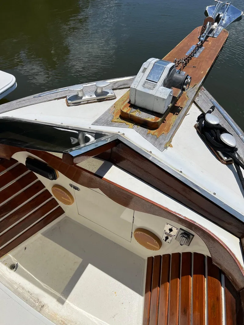 Slide: The Image of 1986 Midnight Lace 44 Flybridge Express Cruiser bow with anchor and wooden deck details. - 16