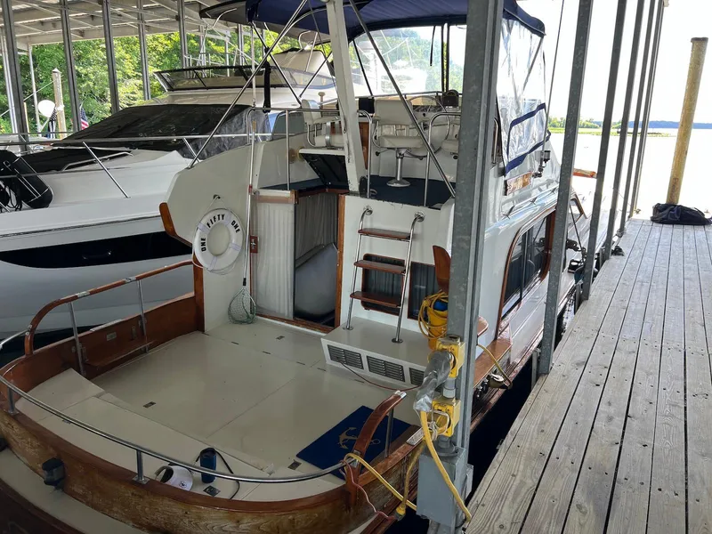 Slide: The Image of 1986 Midnight Lace 44 Flybridge Express Cruiser docked in a marina. - 2