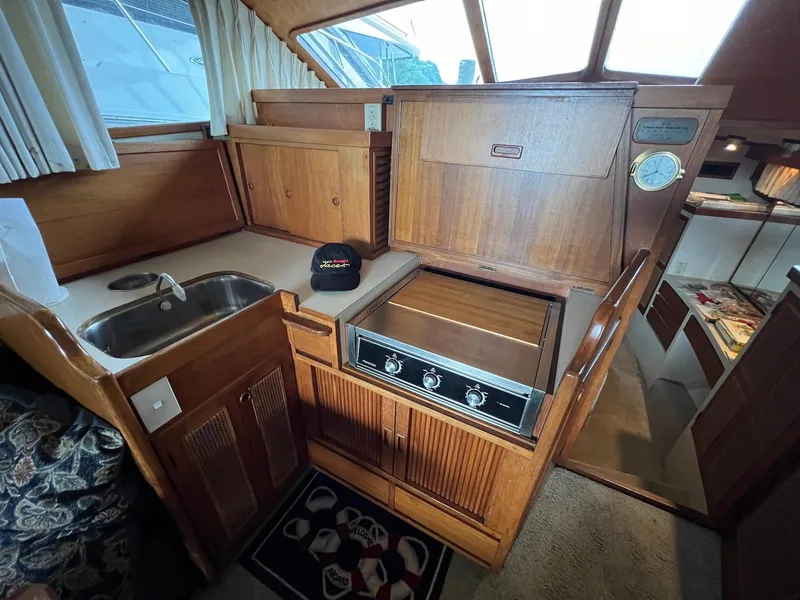Slide: The Image of 1986 Midnight Lace 44 Flybridge Express Cruiser kitchen with wood cabinetry and compact appliances. - 21