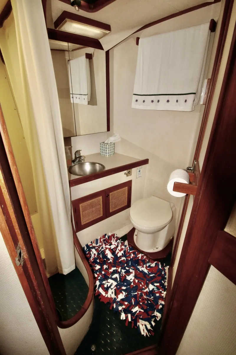 Slide: The Image of 1986 Midnight Lace 44 Flybridge Express Cruiser bathroom with sink, toilet, and colorful rug. - 23