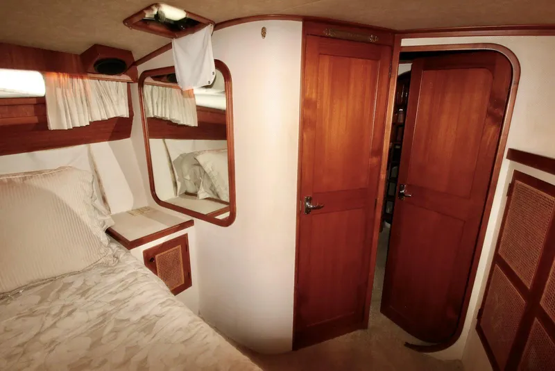 Slide: The Image of 1986 Midnight Lace 44 Flybridge Express Cruiser cabin with wood accents and cozy bedding. - 26
