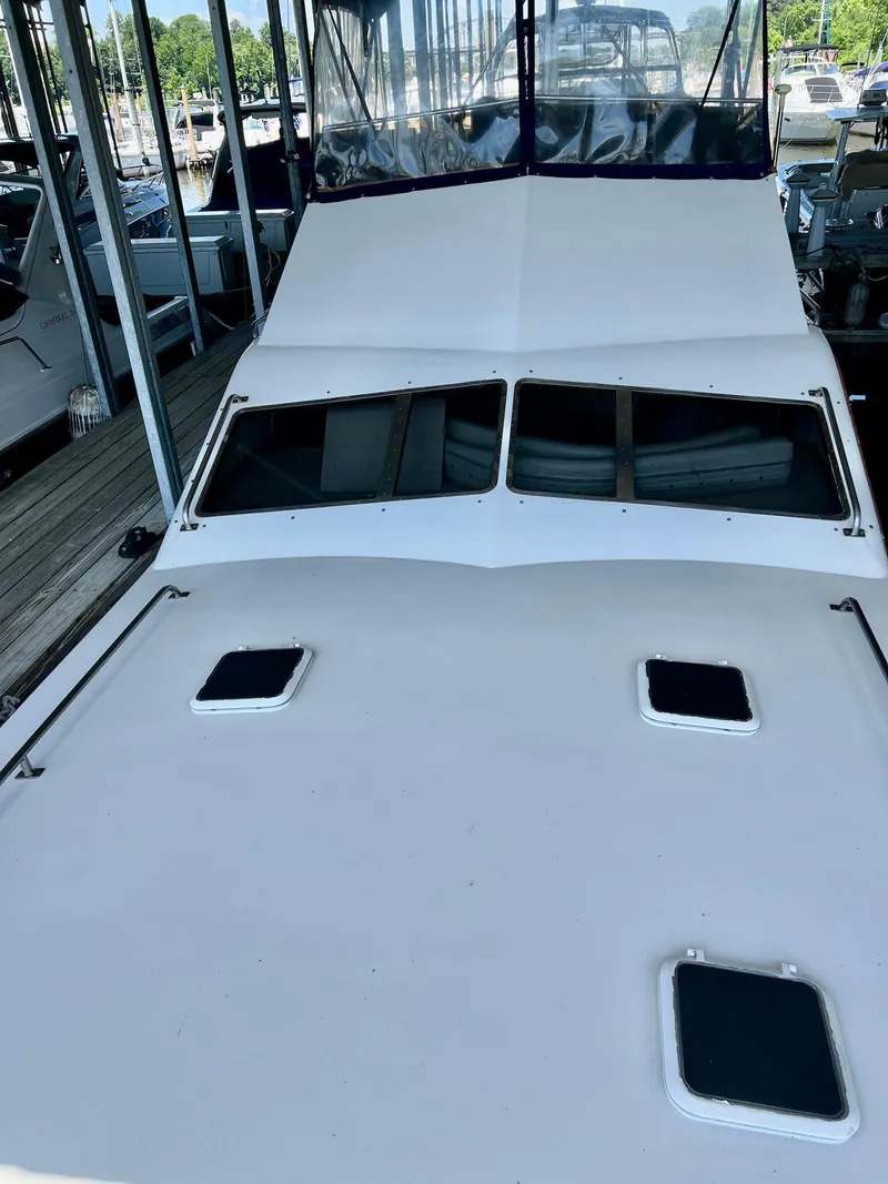 Slide: The Image of 1986 Midnight Lace 44 Flybridge Express Cruiser docked, showcasing sleek design and spacious deck. - 5