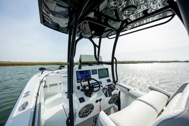 Slide: The Image of 2025 Yellowfin 26 Hybrid boat interior with advanced navigation system on calm waters. - 13